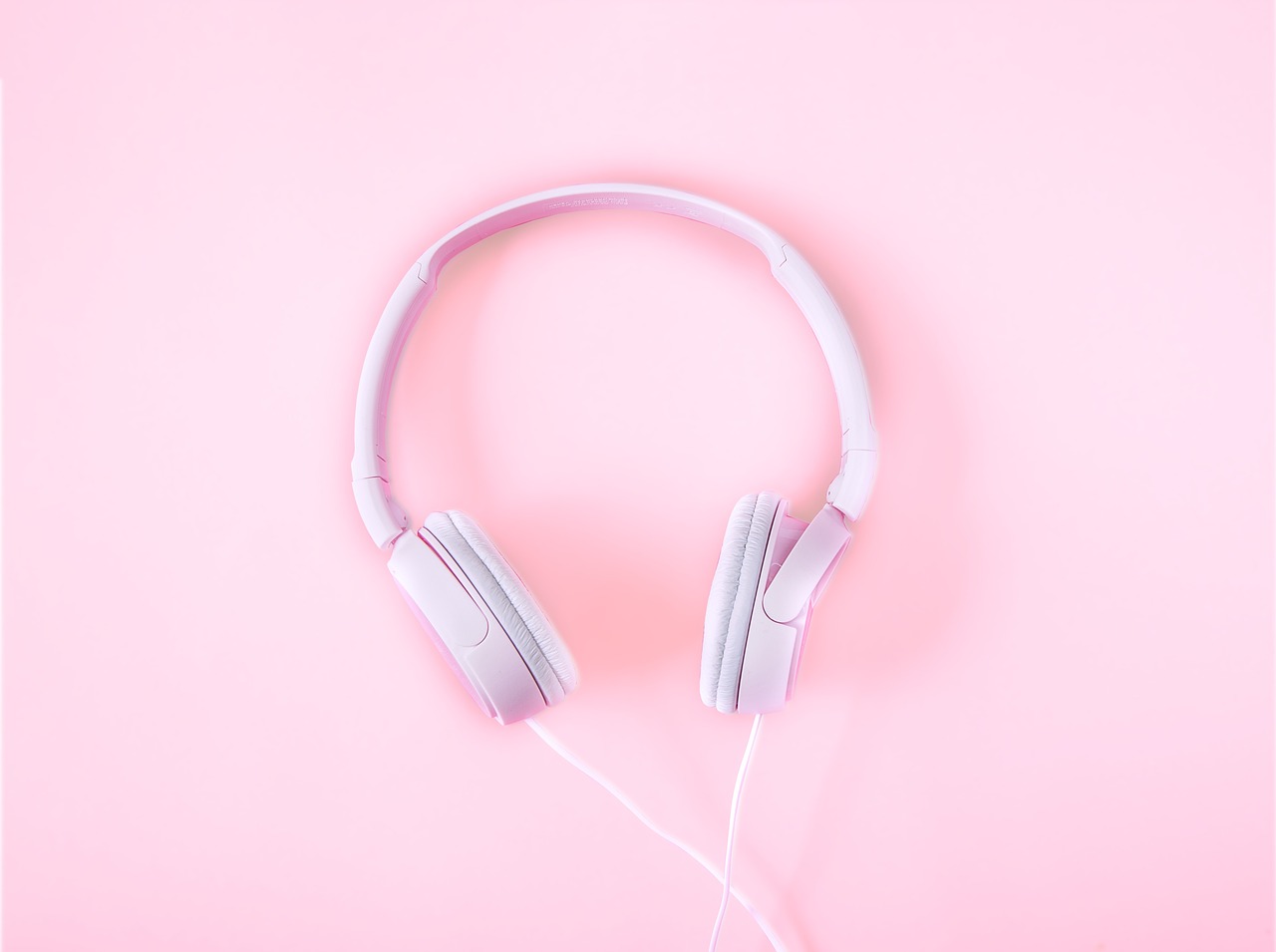weißer Kopfhörer auf rosa Hintergrund